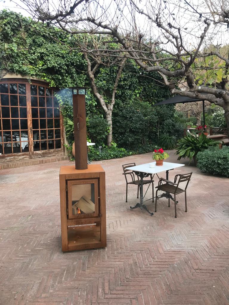 Estufa de leña Quaruba de acero corten en un jardín